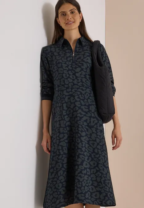 Midikleid mit Zipperdetail und Leo-Muster dark navy blue Frau in Midi-Hemdkleid mit grün-blauem Muster und Schulter-Tasche vor hellem Hintergrund.