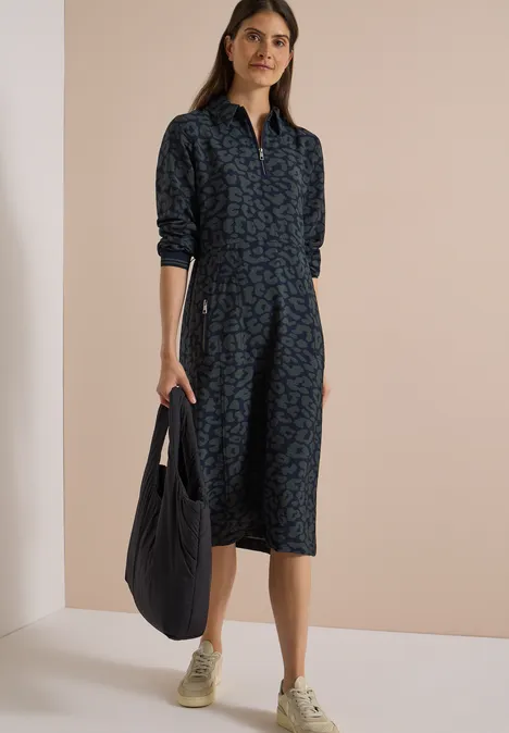 Midikleid mit Zipperdetail und Leo-Muster dark navy blue Frau in knieumspielendem dunkelblauen Hemdkleid mit Muster, aufgekrempelten Ärmeln, beigen Sneakern und Tasche.