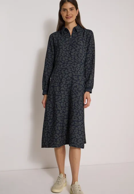Midikleid mit Zipperdetail und Leo-Muster dark navy blue Frau im blauen gemusterten Midikleid mit Kragen und langen Ärmeln, kombiniert mit weißen Sneakern.
