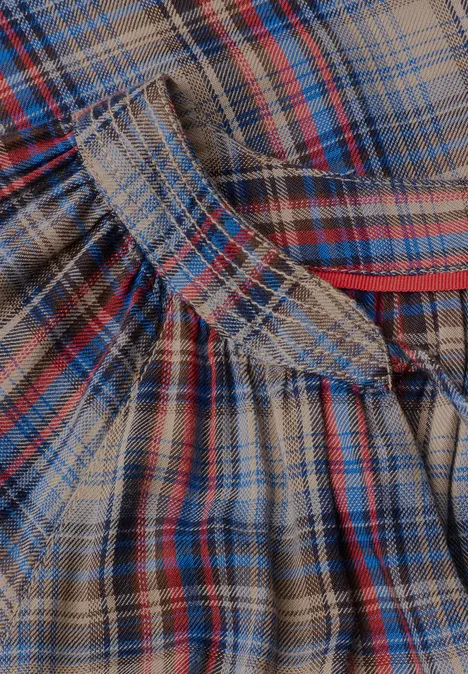 Nahaufnahme eines karierten Flanellstoffs in Braun, Blau und Rot mit Falten und Nahtdetails.