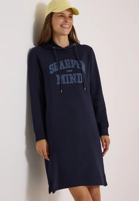 Frau trägt dunkelblaues Hoodie-Kleid mit Kapuze und aufgedrucktem „Sea the mind“-Schriftzug.