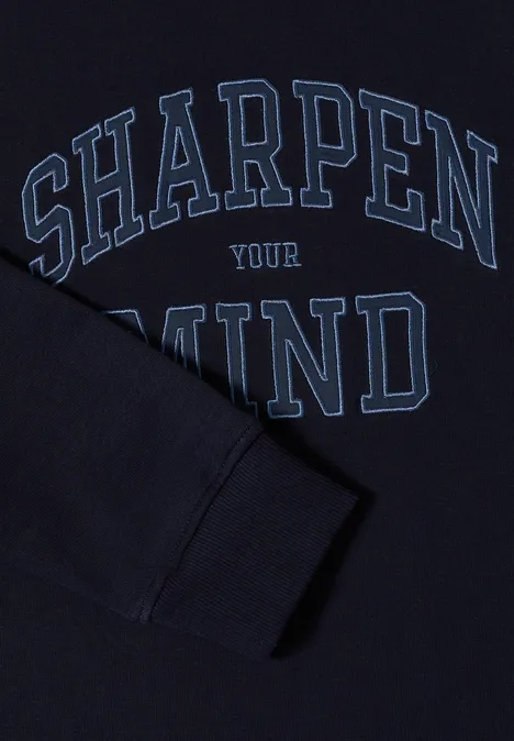Dunkelblauer Pullover mit hellblauem Schriftzug 'SHARPEN YOUR MIND' und einem Ärmel, der das Motiv überdeckt.