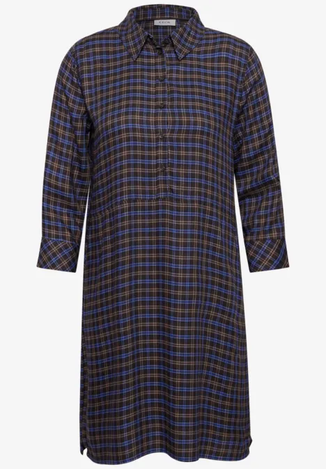 Ein knie- bis wadenlanger Hemdblusenkleid mit blau-braunem Karomuster und 3/4-Ärmeln.