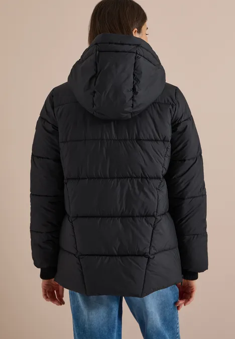 Rückansicht einer Person in schwarzer, wattierter Jacke mit Kapuze auf hellem Hintergrund.