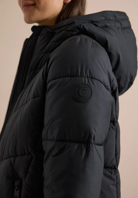Schwarz gepolsterte Kapuzenjacke in Seitenansicht an einer Frau.