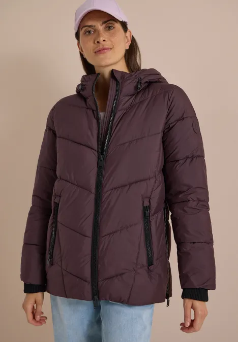 Puffer-Jacke in Midi-Länge mit Kapuze berry red Frau in violettem Steppmantel mit Kapuze und Cap, lässiger Freizeitlook.