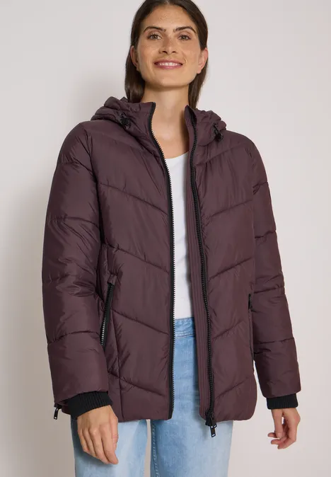 Puffer-Jacke in Midi-Länge mit Kapuze berry red Frau in violettem, gepolstertem Winterparka mit Kapuze lächelt freundlich.