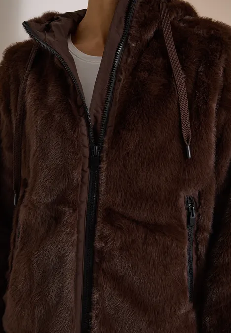 Nahaufnahme einer braunen, flauschigen Jacke mit Reißverschluss und Kapuze.