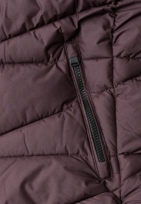 Veste matelassée à capuche et fermeture zip berry red Gros plan sur une doudoune matelassée brun-violet avec poche zippée en biais.