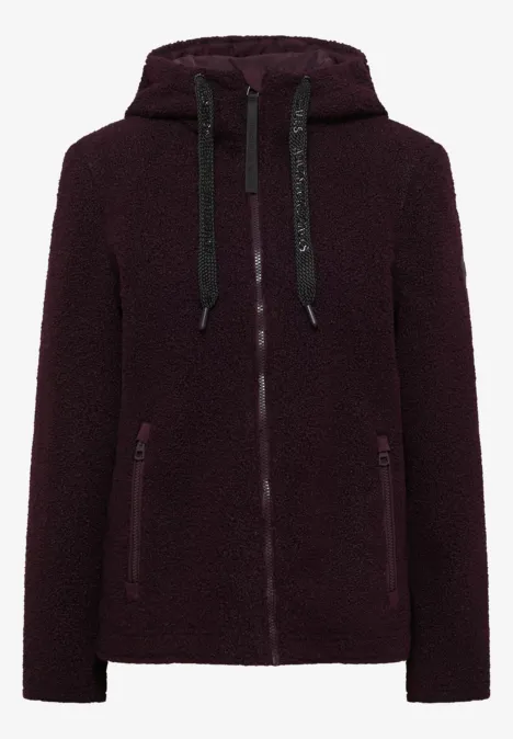Veste en fausse fourrure bordeaux à capuche, zippée, avec poches latérales.