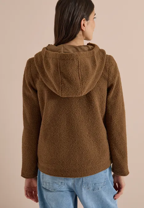 Frau von hinten trägt braune Teddy-Fleece-Jacke mit Kapuze.