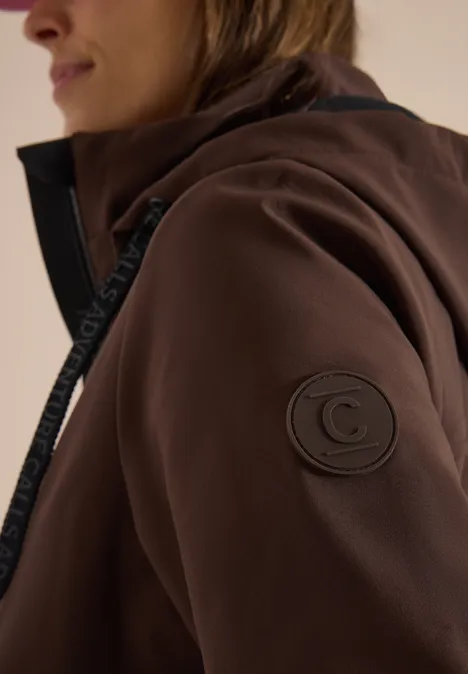 Veste marron avec fermeture éclair et logo rond sur la manche.