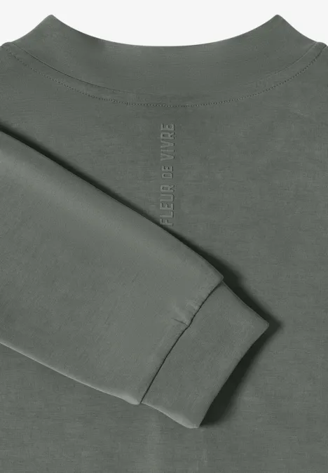 Olivgrüner Sweatshirt-Oberteil mit gefaltetem Ärmel auf hellem Hintergrund