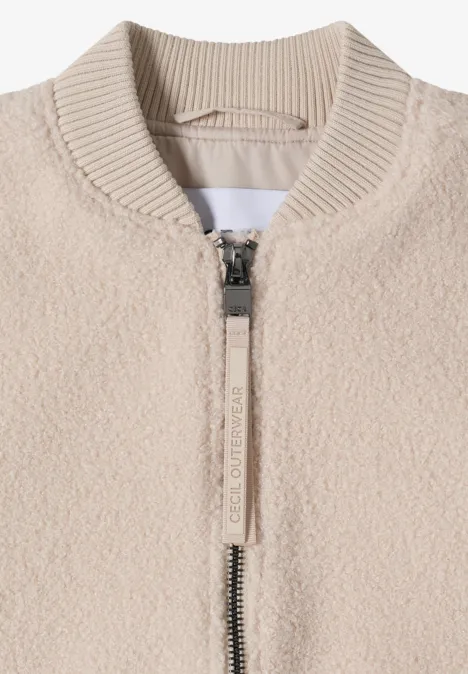 Beige teddy-fleecejas met ritssluiting en geribde opstaande kraag.