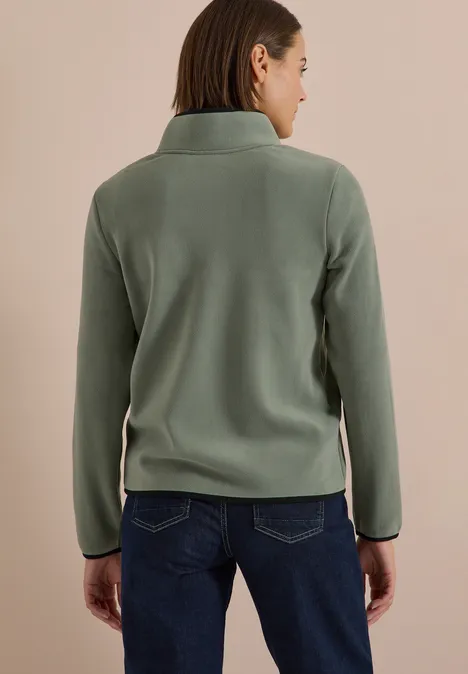 Fleecejacke mit Zipper und Stehkragen shadow khaki Person von hinten in grünem Fleecepulli und dunkler Jeans vor beigem Hintergrund.