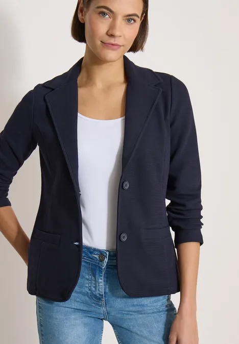 Blazer mit Struktur in Unifarbe urban dark blue Eine Frau trägt einen dunkelblauen Blazer, weißes Top und Jeans vor hellem Hintergrund.