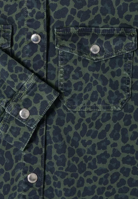 Grüne Hemdjacke mit schwarzem Leopardenmuster, aufgesetzter Brusttasche und silbernen Druckknöpfen.