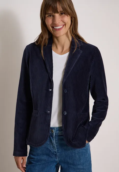 Jerseycord Blazer in Unifarbe urban dark blue Frau in dunkelblauem Blazer, weißem T-Shirt und Jeans, lächelnd.