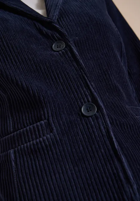 Jerseycord Blazer in Unifarbe urban dark blue Nahaufnahme eines dunkelblauen Cord-Sakkos mit Knöpfen und eingesetzter Tasche.