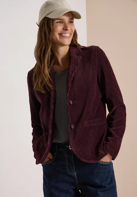 Jerseycord Blazer in Unifarbe berry red Frau mit Baseballcap in lila Cord-Blazer lächelt und posiert in Jeans.