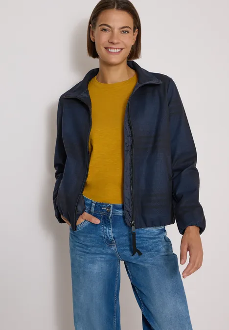 Karierte Jacke in Wolloptik mit Stehkragen urban dark blue melange Eine lächelnde Frau trägt eine dunkelblaue Jacke, gelbes Shirt und blaue Jeans.
