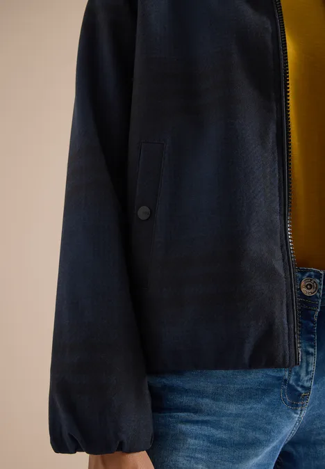 Karierte Jacke in Wolloptik mit Stehkragen urban dark blue melange Eine Person trägt eine dunkelblaue Jacke mit Bündchenärmeln, ein gelbes Shirt und blaue Jeans.