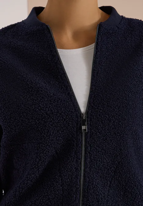 Veste polaire bleu marine à zip sur un t-shirt blanc.