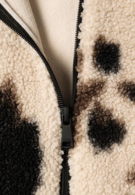 Nahaufnahme einer Reißverschlussjacke aus Teddyfell mit braun-schwarzem Fleckenmuster.