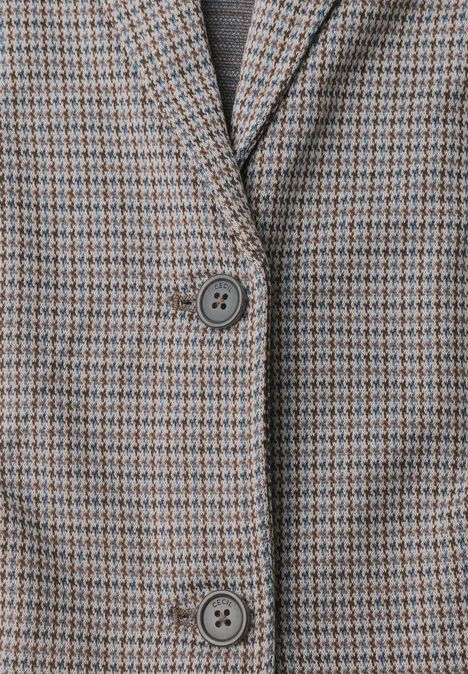 Nahaufnahme eines karierten Blazers mit zwei Knöpfen in gedeckten Braun- und Grautönen.