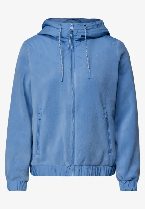 Leichte hellblaue Kapuzenjacke mit Reißverschluss, elastischem Saum und seitlichen Taschen.