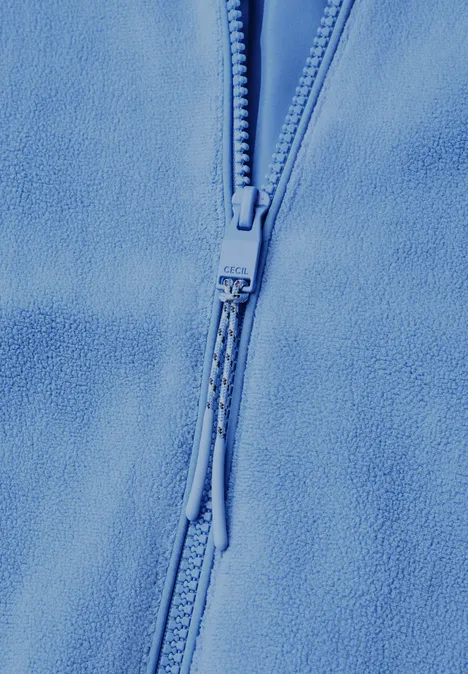 Nahaufnahme eines hellblauen Fleece-Pullovers mit Reißverschluss und Zipper-Pulls.