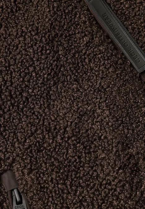 Nahaufnahme eines flauschigen braunen Teddy-Fleece-Stoffs mit Reißverschlussdetails.