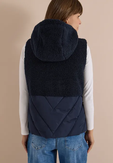 Teddy-Weste mit Steppteil und Zipper dark navy blue Rückenansicht einer Person in dunkelblauer, zweifarbiger Weste mit Kapuze und Teddyfell-Oberteil.