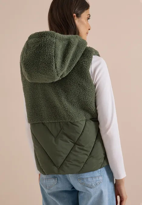 Teddy-Weste mit Steppteil und Zipper shadow khaki Damenweste mit Kapuze: Oben flauschiges Teddy-Fleece, unten gestepptes Material, in Olivgrün.