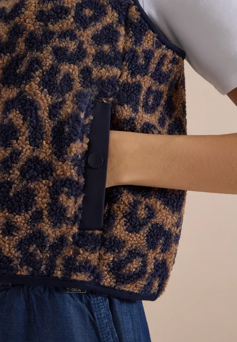Teddy-Weste mit Softshelldetails und Leo-Muster creamy mocha Flauschige Weste mit Leopardenmuster, Hand in Reißverschlusstasche gesteckt.