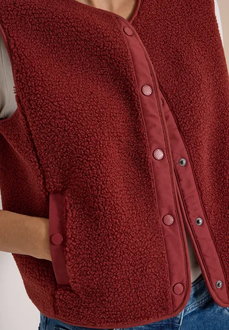 Rote ärmellose Teddy-Fleece-Weste mit Druckknöpfen und Taschen.