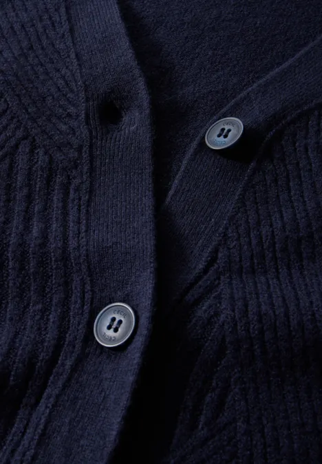 Dunkelblauer Strickstoff mit zwei Knöpfen, Detailaufnahme einer Strickjacke.