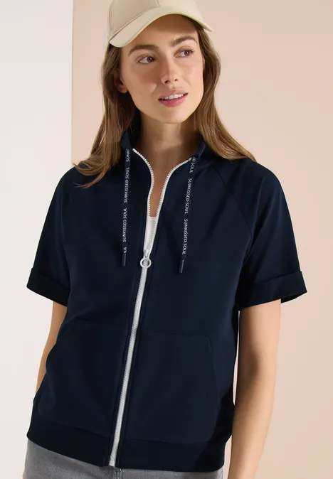 Femme portant un sweat à capuche bleu marine à manches courtes et fermeture éclair.