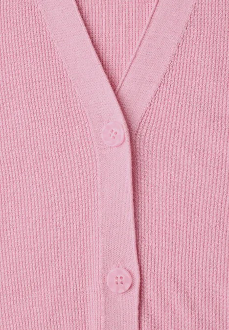Nahaufnahme eines rosa Strickcardigans mit Knöpfen
