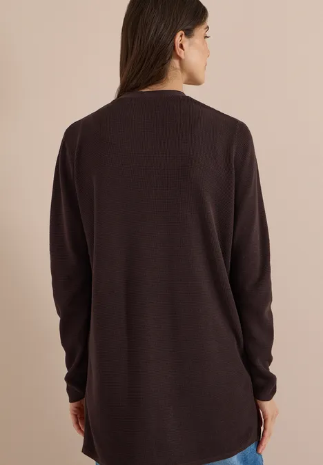 Femme vue de dos portant un pull ample à manches longues de couleur brun foncé.