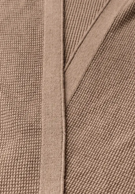 Braunes, feinstricktes Gewebe mit Rippenstruktur in Nahaufnahme.
