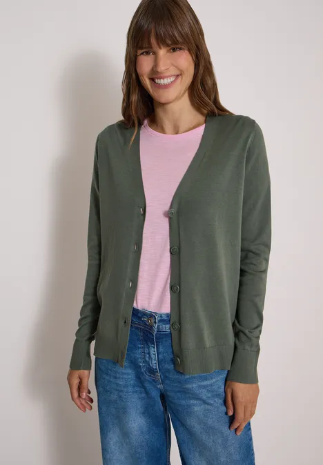 Cardigan mit V-Neck und Knopfleiste dried olive green Eine Frau trägt eine grüne Strickjacke über ein rosa Shirt und blaue Jeans.