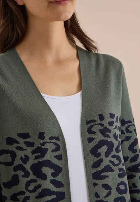 Damen-Cardigan in Olivgrün mit schwarzem Leopardenmuster über weißem Top, mittlerer Bildausschnitt