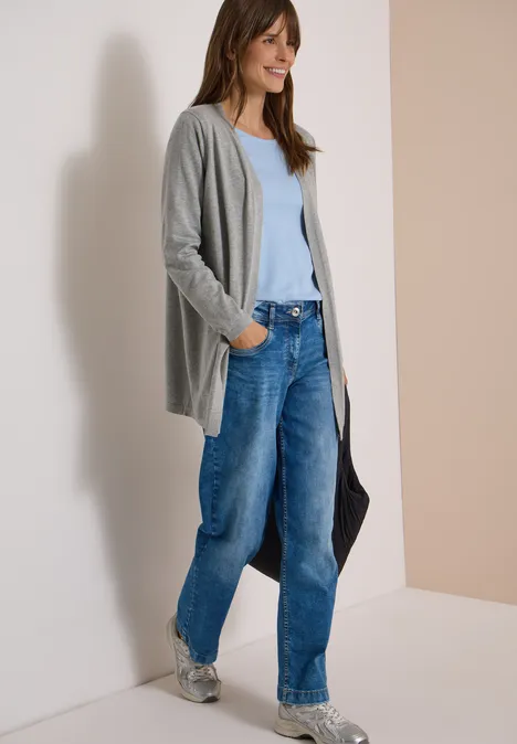 Offener Cardigan in langer Passform mineral grey melange Frau trägt graue Strickjacke, hellblaues Top, weite Jeans und Sneaker, hält eine schwarze Tasche.