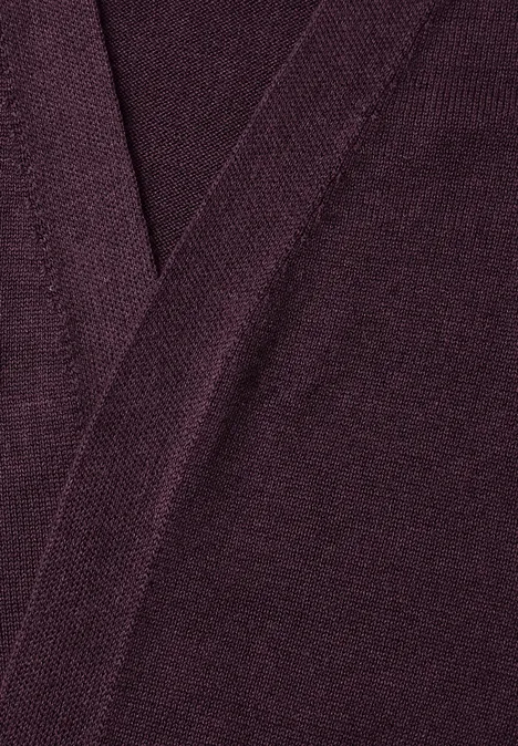 Gros plan sur un tissu tricoté violet foncé avec couture visible en forme de V.