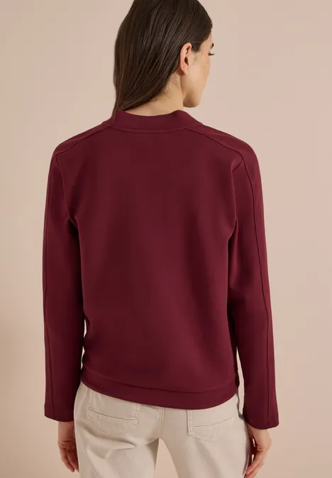 Sweat Blouson mit Tunnelzug red wine Frau von hinten in dunkelrotem Sweatshirt und hellen Hosen vor hellem Hintergrund.