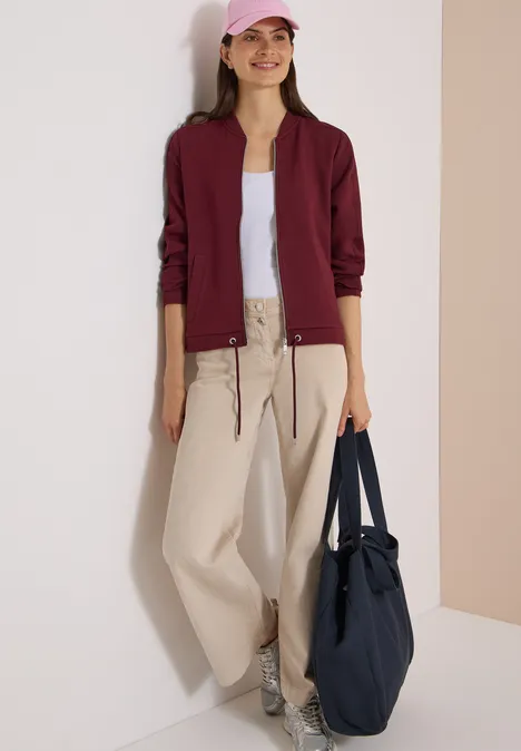 Sweat Blouson mit Tunnelzug red wine Junge Frau in Burgunderjacke, weißem Top, beigen Hosen, Sneakern und großer Tasche.