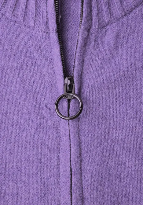 Cardigan zippé à manches longues et col rond pastel lilac melange Nahaufnahme eines lila Strickpullovers mit Reißverschluss und rundem Zipperanhänger.