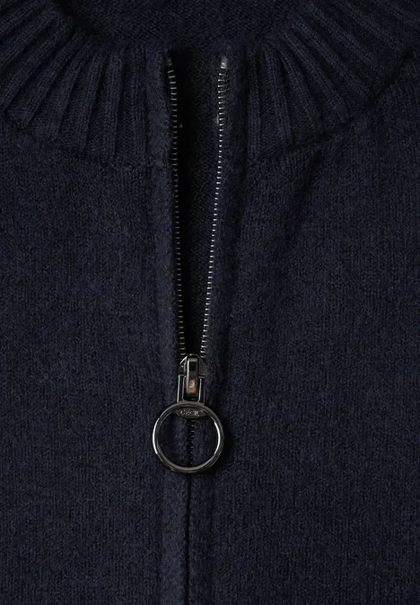 Nahaufnahme eines dunkelblauen Strickpullovers mit Reißverschluss und rundem Reißverschlussanhänger
