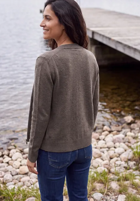 Langarm Cardigan mit Rundhals und Zipper mushroom taupe melange Eine Frau steht am Ufer, schaut lächelnd über den See weg.